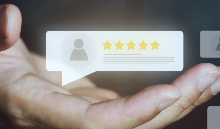 a hand holding a paper with stars and a person's profile