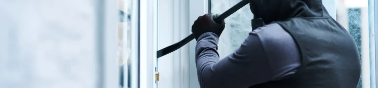 Man opening up a house with a tool
