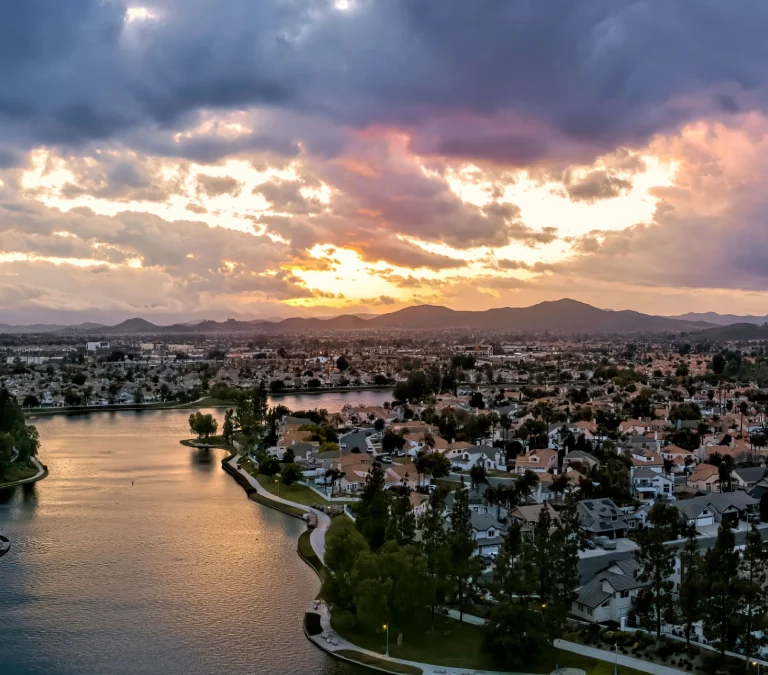 a body of water with houses and trees in the foreground