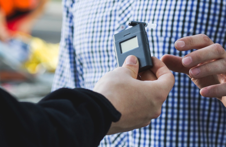 Policeman giving a breathalyzer to a driver
