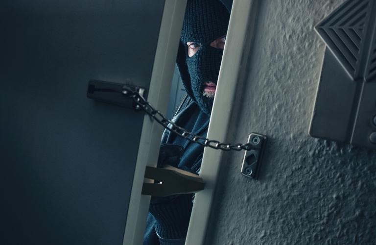 burglar with crowbar breaking into a victim's home