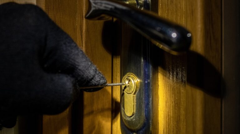 thief tries to open the lock in the door with a special key