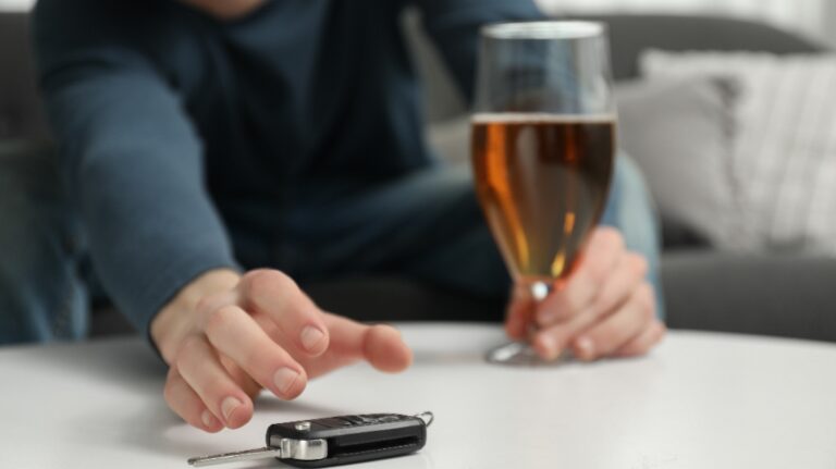 Drunk man reaching for car keys indoors