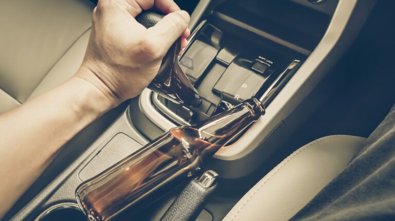 driver holding alcoholic bottle while driving