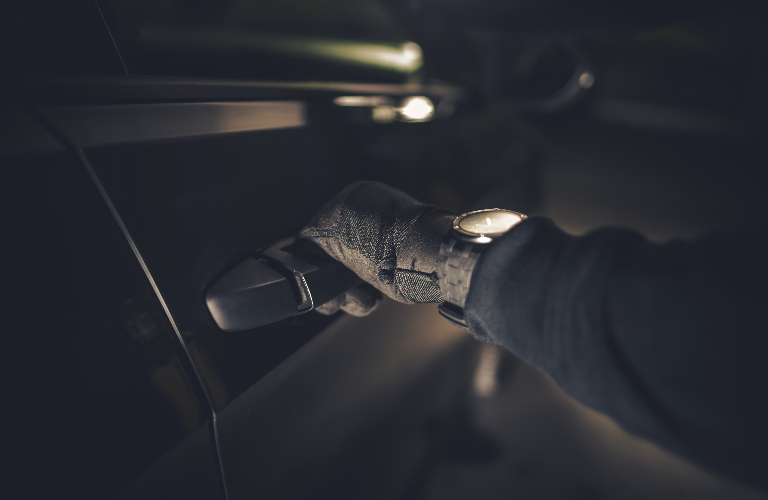 thief is trying to open a car